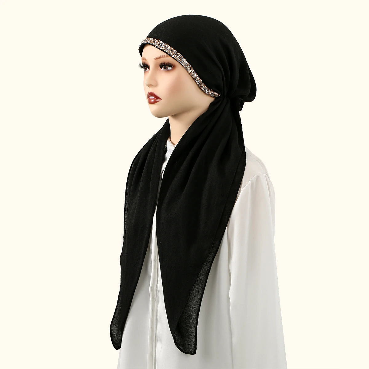 Une femme portant un bonnet hijab en lin noir uni avec une bordure scintillante et un haut blanc.