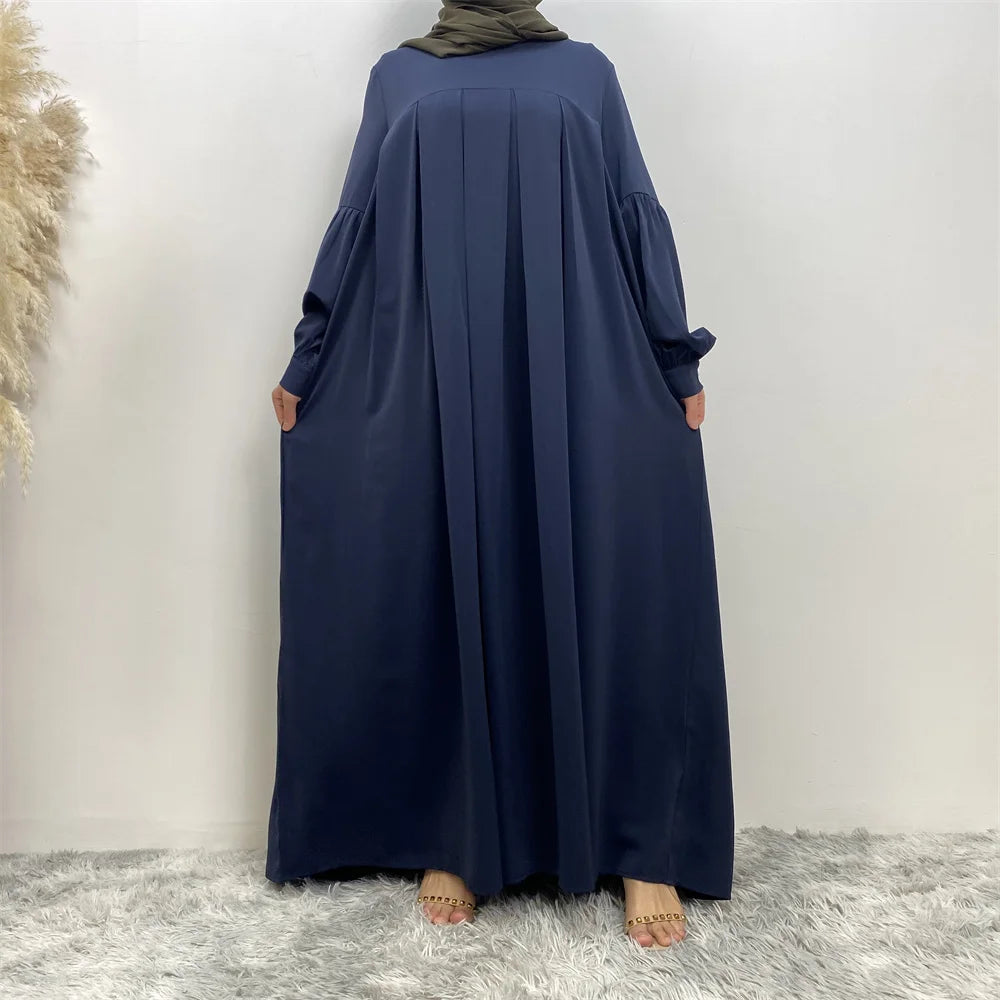 Langes marineblaues islamisches Kleid, weit geschnittene Ärmel und fließende Silhouette.