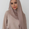 A woman wearing a beige soft modal rayon hijab set with a high neck top and skirt.