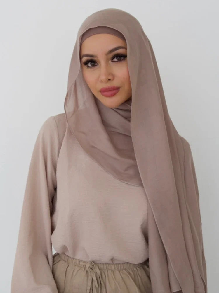 A woman wearing a beige soft modal rayon hijab set with a high neck top and skirt.