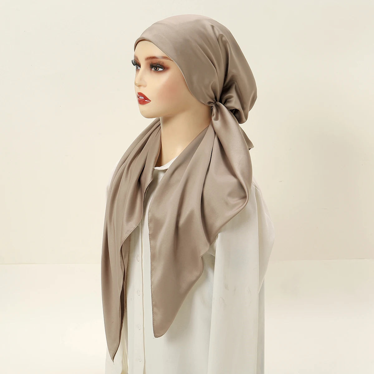 A model wears an elegant satin silk instant hijab scarf in beige over a white top.
