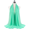 A bright mint green chiffon hijab scarf draped around a mannequin's neck.