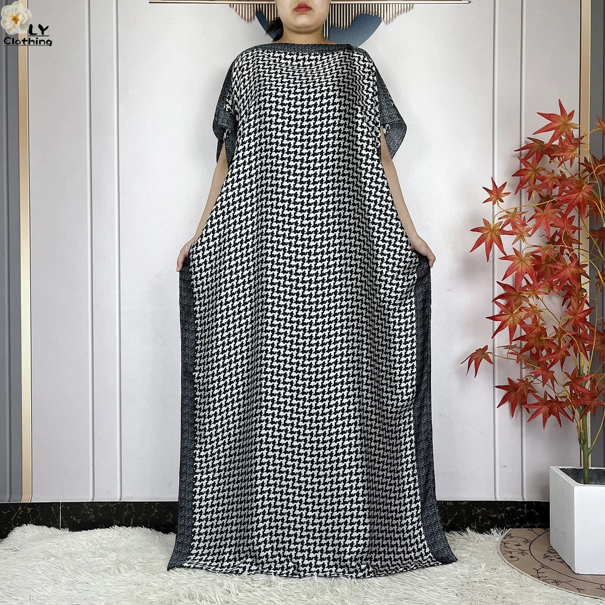 Eine Frau modelliert ein schwarz-weiß gemustertes Sommerseiden-Abaya-Kaftankleid.