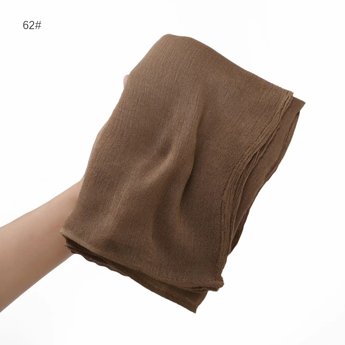Gros plan d'un châle en crinkle de rayon marron drapé sur une main.