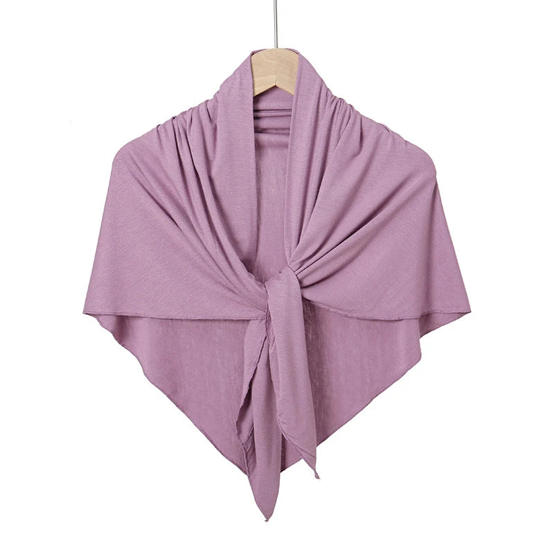 Foulard hijab triangle lilas plié et suspendu sur une perche en bois.