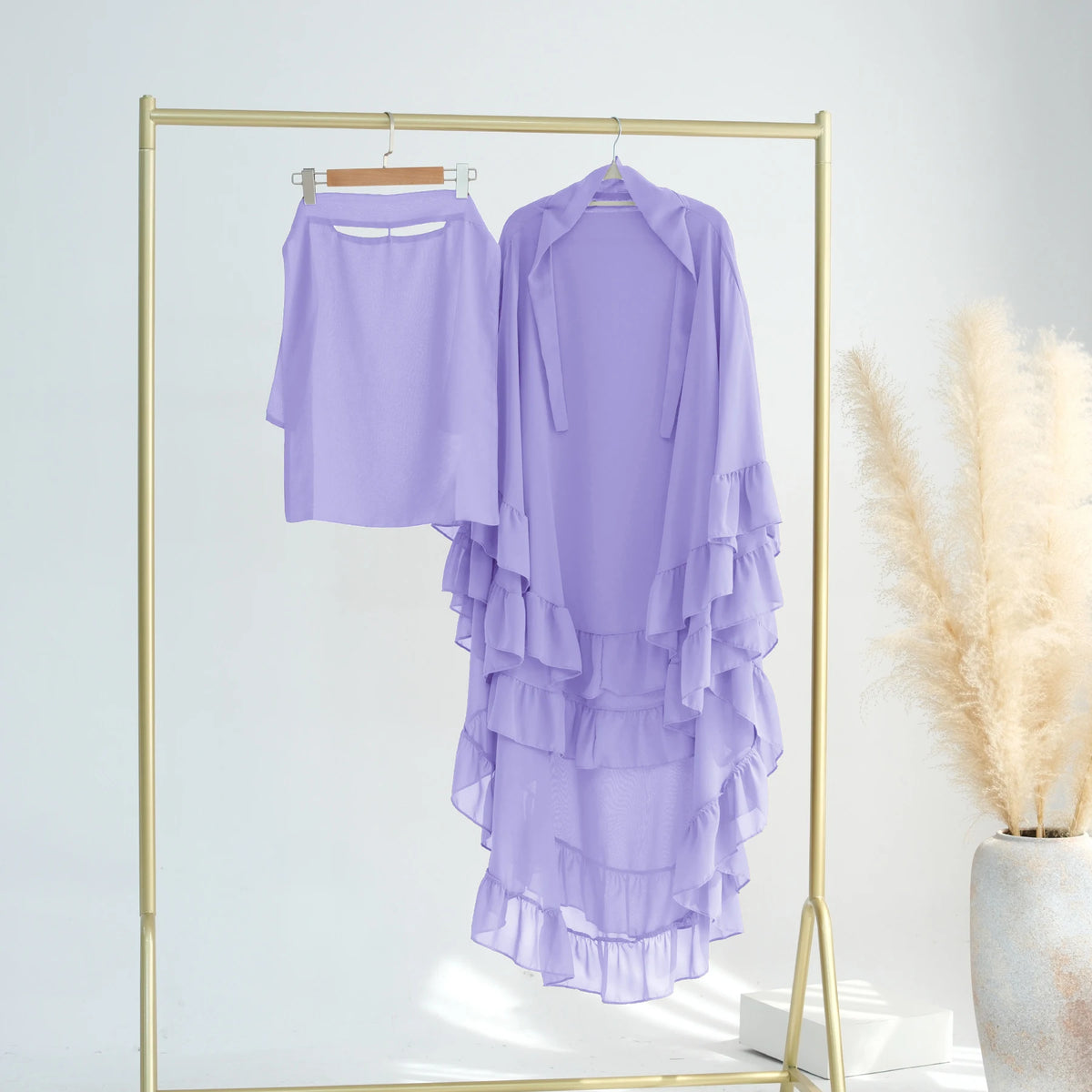 A purple ruffled 2-layer chiffon hijab displayed on a gold hanger against a white background.