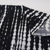 Nahaufnahme eines schwarz-weißen Tie-Dye Sommer-Strandkimonos-Überkleidstoffes.