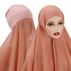 Una mujer vistiendo un conjunto de hijab y chal de gasa color melocotón.