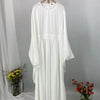 Elegane weiße Batwing-Abaya für Damen, an einem Kleiderbügel vor grauem Hintergrund.