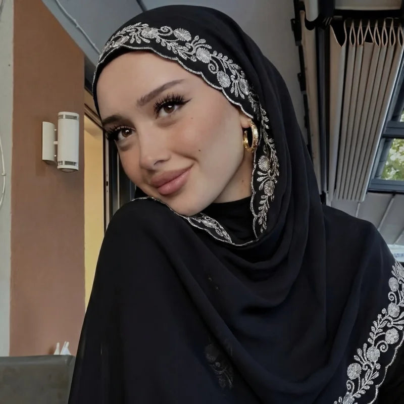 Une femme portant un foulard chiffon noir avec une bordure de dentelle d'eyelash ouvragée.