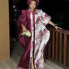 A woman wearing an elegant, flowing maroon and white kaftan with tatting detail, standing outdoors.