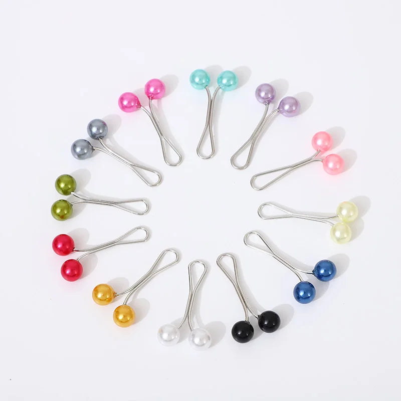 Un arrangement circulaire de clips et épingles à cristaux strass colorés sur fond blanc.