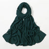 Ein dunkeltealer Chiffon-Schal elegant um den Hals und die Schultern drapiert.