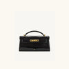 A black crocodile pattern shoulder bag with gold hardware.
