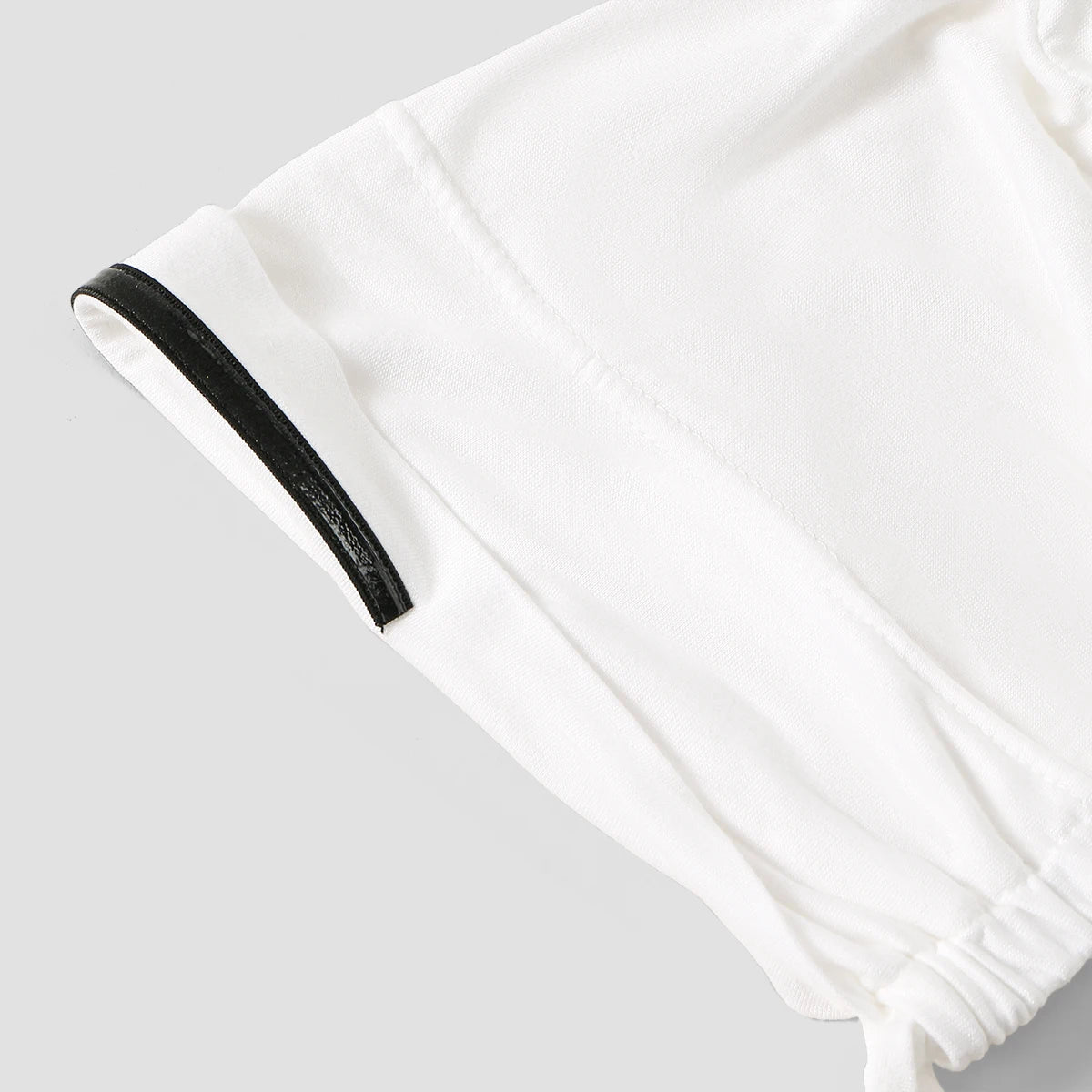 White inner hijab cap with a black trim and gathered fabric detail.