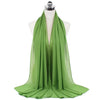A bright green chiffon hijab scarf draped around a mannequin's neck.