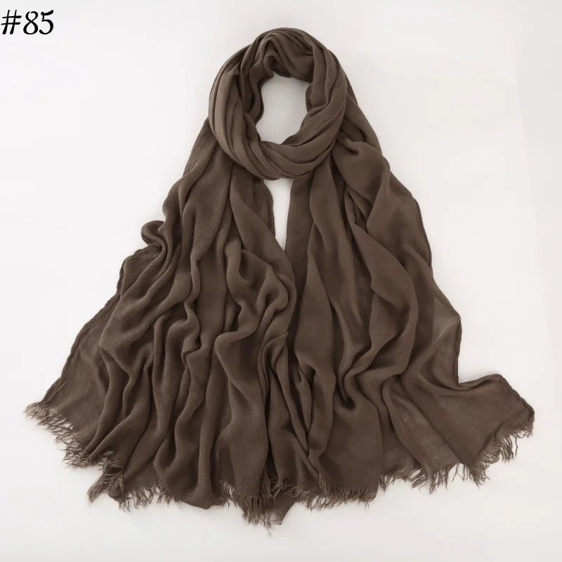 Foulard hijab en coton viscose brun foncé, drapé et plié sur fond blanc.