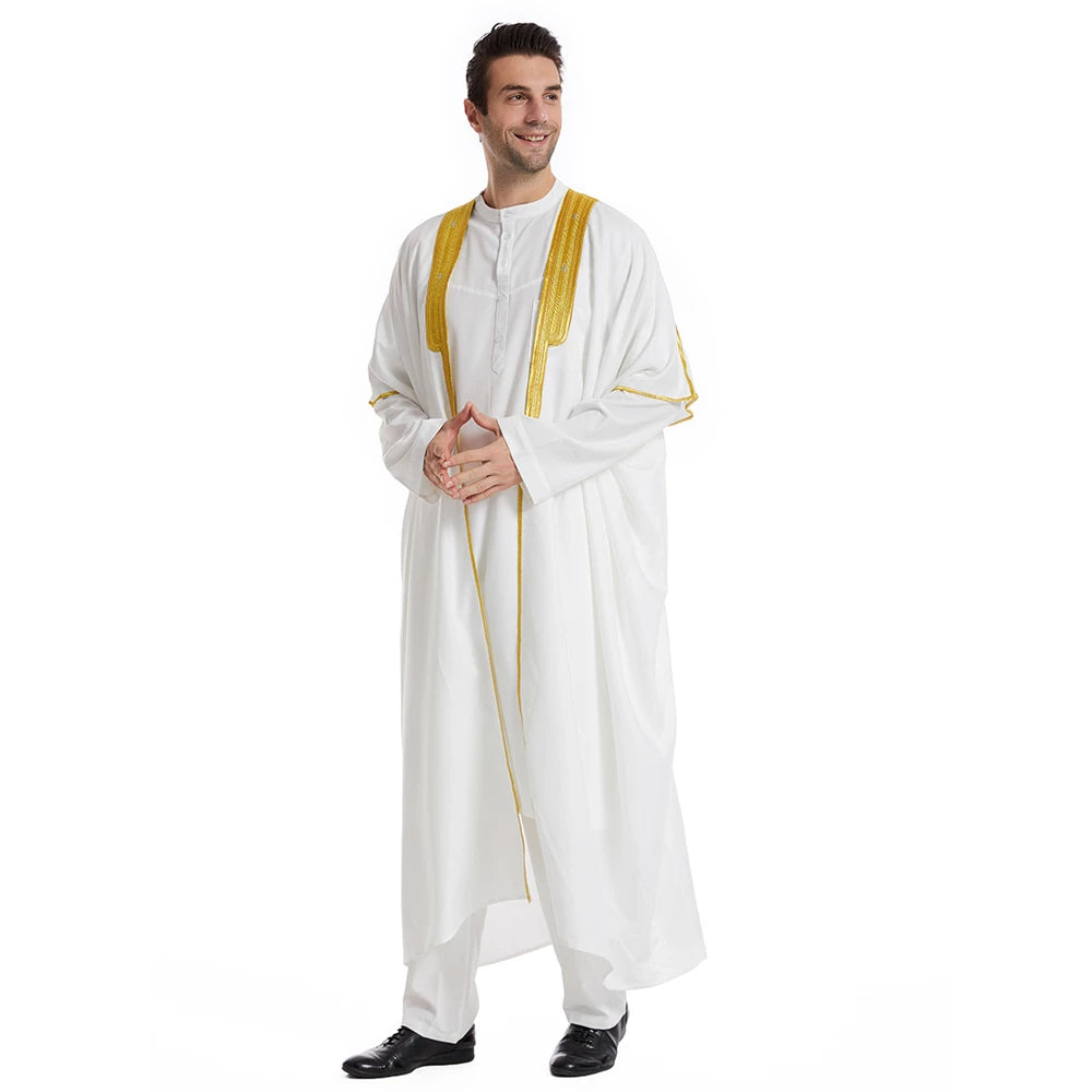 Mann trägt weißen Jubba-Thobe Kaftan mit goldenen Zierkanten und schwarzen Schuhen.