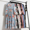 Präsentation verschiedener Boho-Blumenmuster-Maxikleider an einem Kleiderständer.