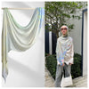 Eine Frau trägt einen hellgrünen Aquarell-Ombré-bedruckten Rayon-Modal-Hijabschal über Kopf und Schultern.