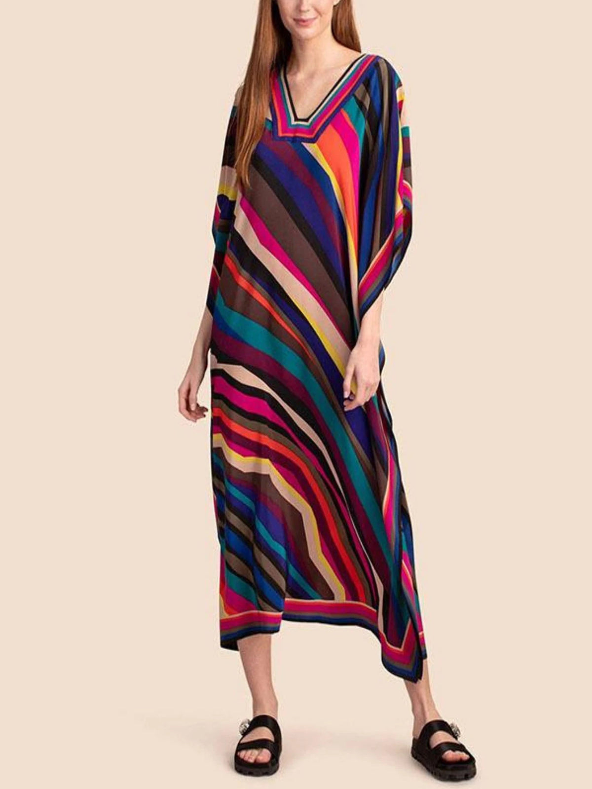 Eine Frau trägt ein farbenfrohes, gestreiftes marokkanisches Batwing-Kaftan-Überkleid.