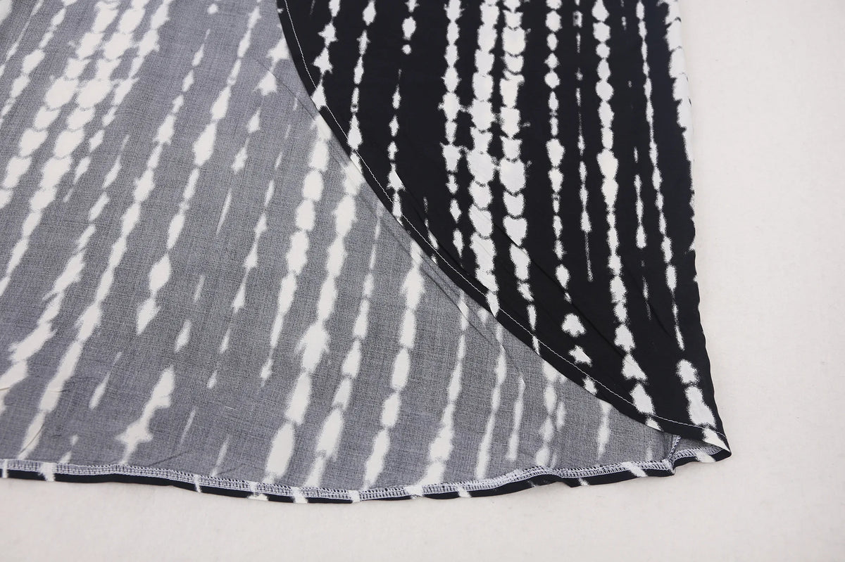 Nahaufnahme eines schwarz-weißen Tie-Dye-Stoffes, wahrscheinlich ein Sommer-Strandkimono-Kleid.