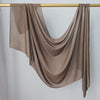 Foulard modal marron uni drapé, suspendu sur un bâton en bois.