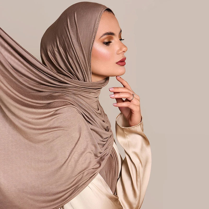 Una mujer usando un pañuelo de hijab de algodón modal premium beige, vista de perfil.