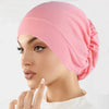 Eine Frau trägt eine rosa Stretch-Turbanmütze
