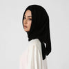 Une femme portant un élégant foulard triangle noir et un haut blanc.