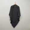 A dark gray two-layer everyday hijab scarf draped on a wooden hanger against a light wall.