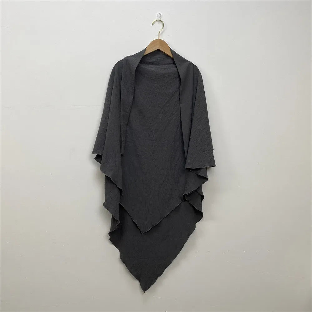 A dark gray two-layer everyday hijab scarf draped on a wooden hanger against a light wall.