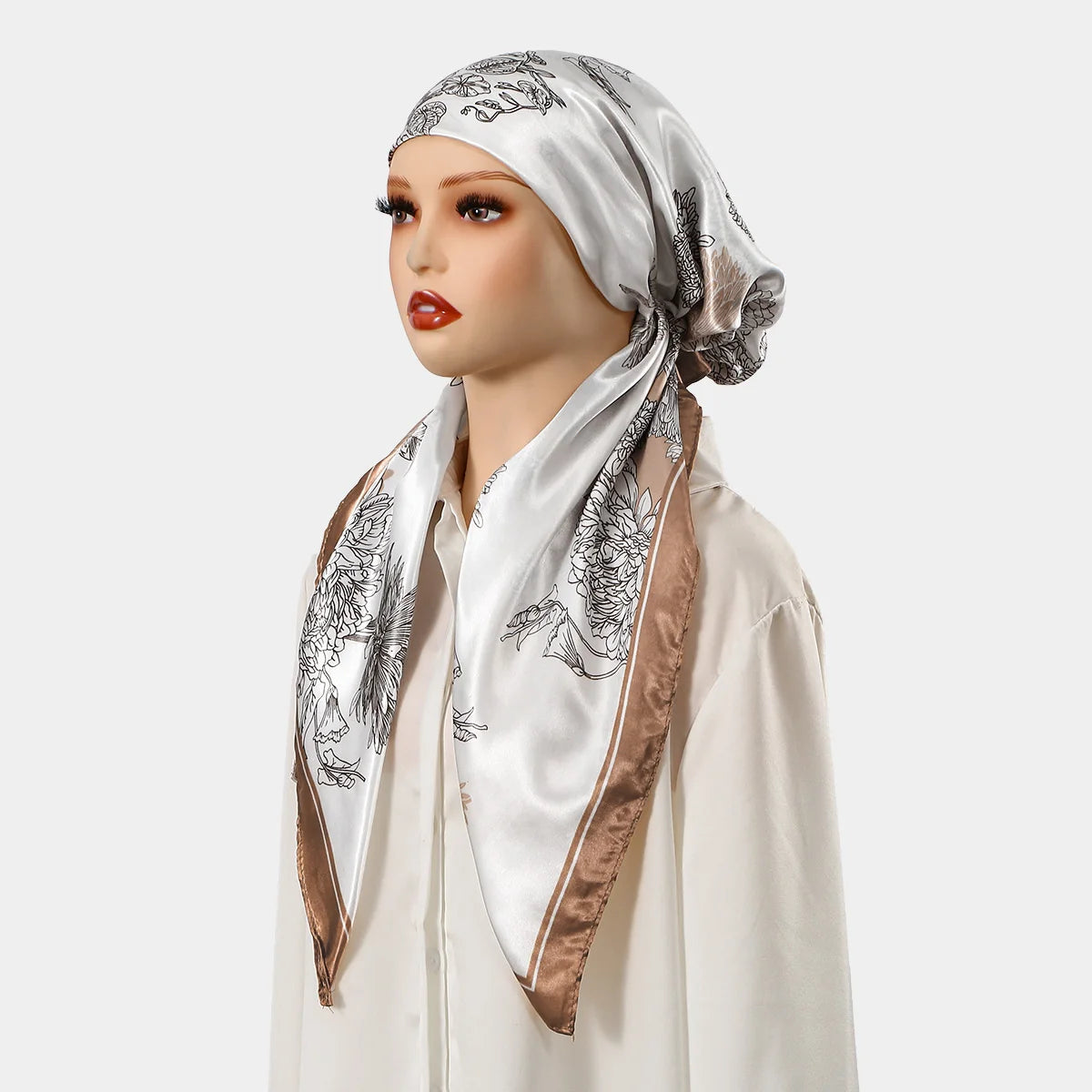 Eine Frau modelliert einen Satin-Seiden-Instant-Hijab-Schal mit weißem und goldenem Blumenmuster