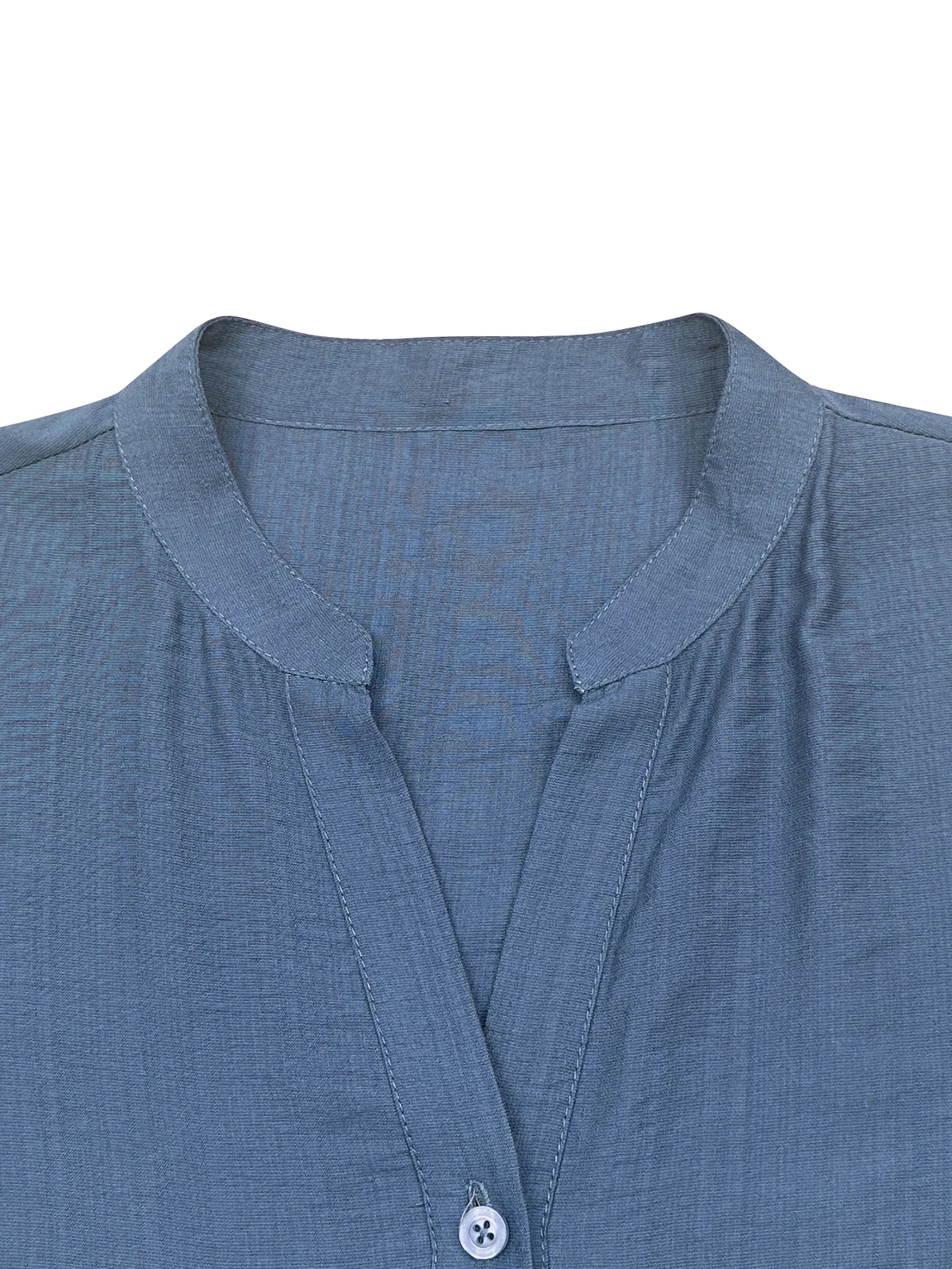 Nahaufnahme eines blauen Leinenhemds mit Kragen und Knopf am Hals.