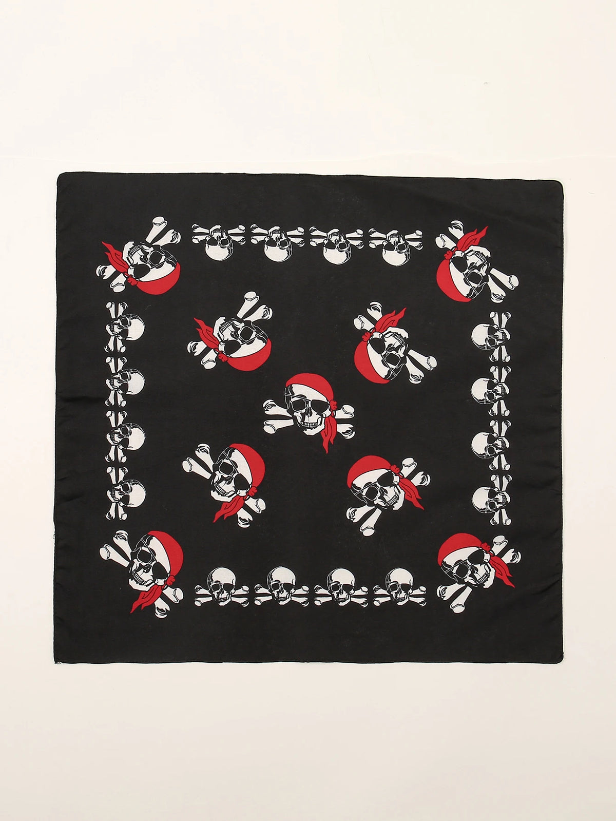 Tissu noir avec un motif répétitif de crânes et de tibias en rouge et blanc.