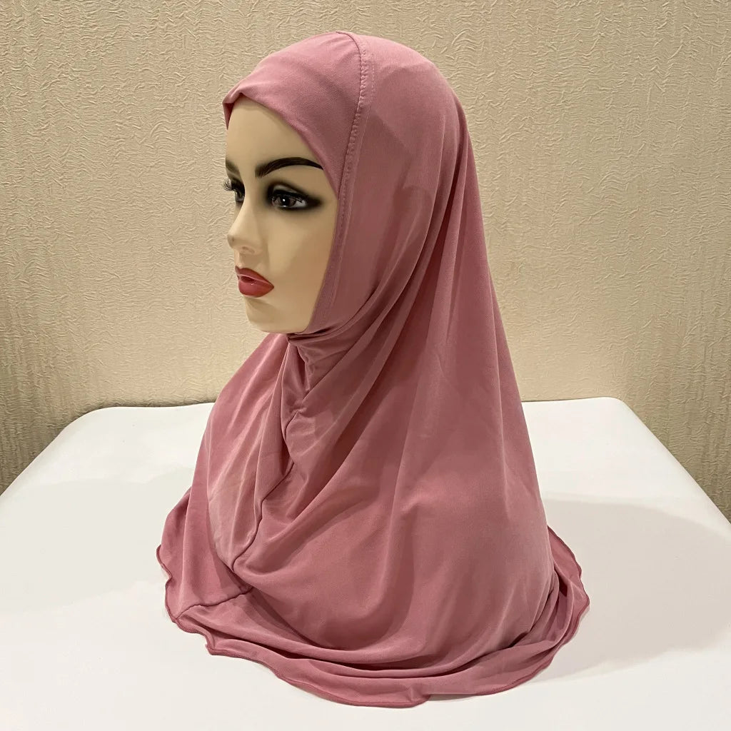 Un chal de hijab rosa para niños de Ramadán, drapeado en un maniquí.