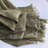 Une pile de foulards hijabs en viscose coton vert olive avec pompons