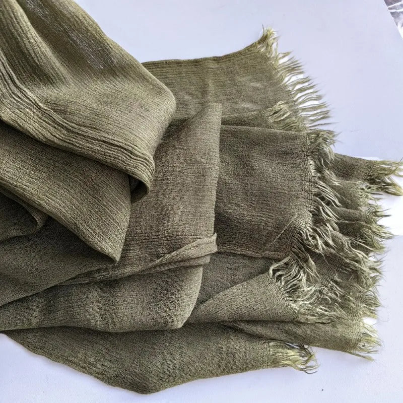 Une pile de foulards hijabs en viscose coton vert olive avec pompons
