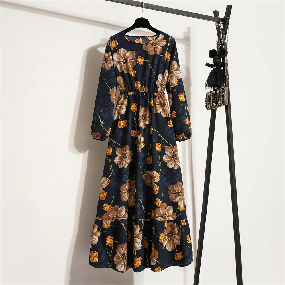 Dunkelblaue Maxi-Kleid mit Blumenmuster auf einem Haken vor einer weißen Wand.