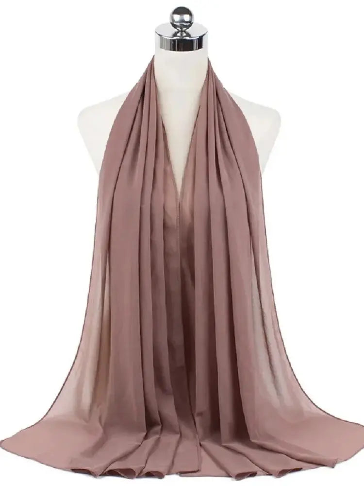 Ein drapierter, fester mauvefarbener Chiffon-Hijab-Schal auf einem Mannequin-Hals.
