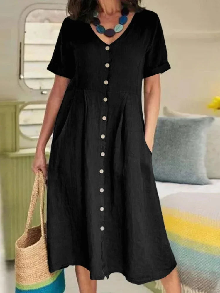 Eine Frau trägt ein elegantes schwarzes Baumwoll- und Hanf-V-Ausschnittkleid mit kurzen Ärmeln und Knöpfen.