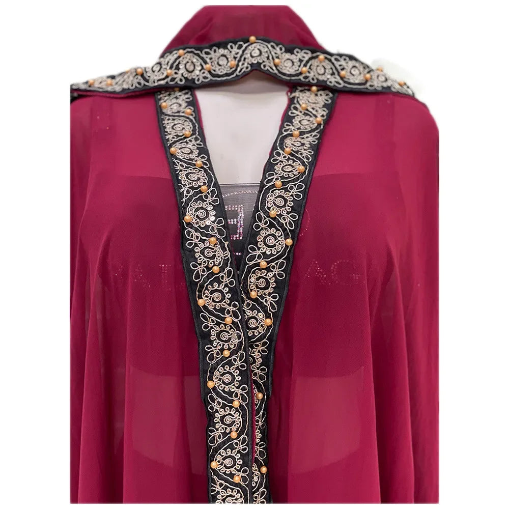 Vestido abaya maxi fluido color granate con mangas de murciélago y bordado negro y dorado en el escote.
