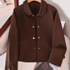 Manteau en laine marron à boutons pour femme, exposé sur un cintre sur fond clair.