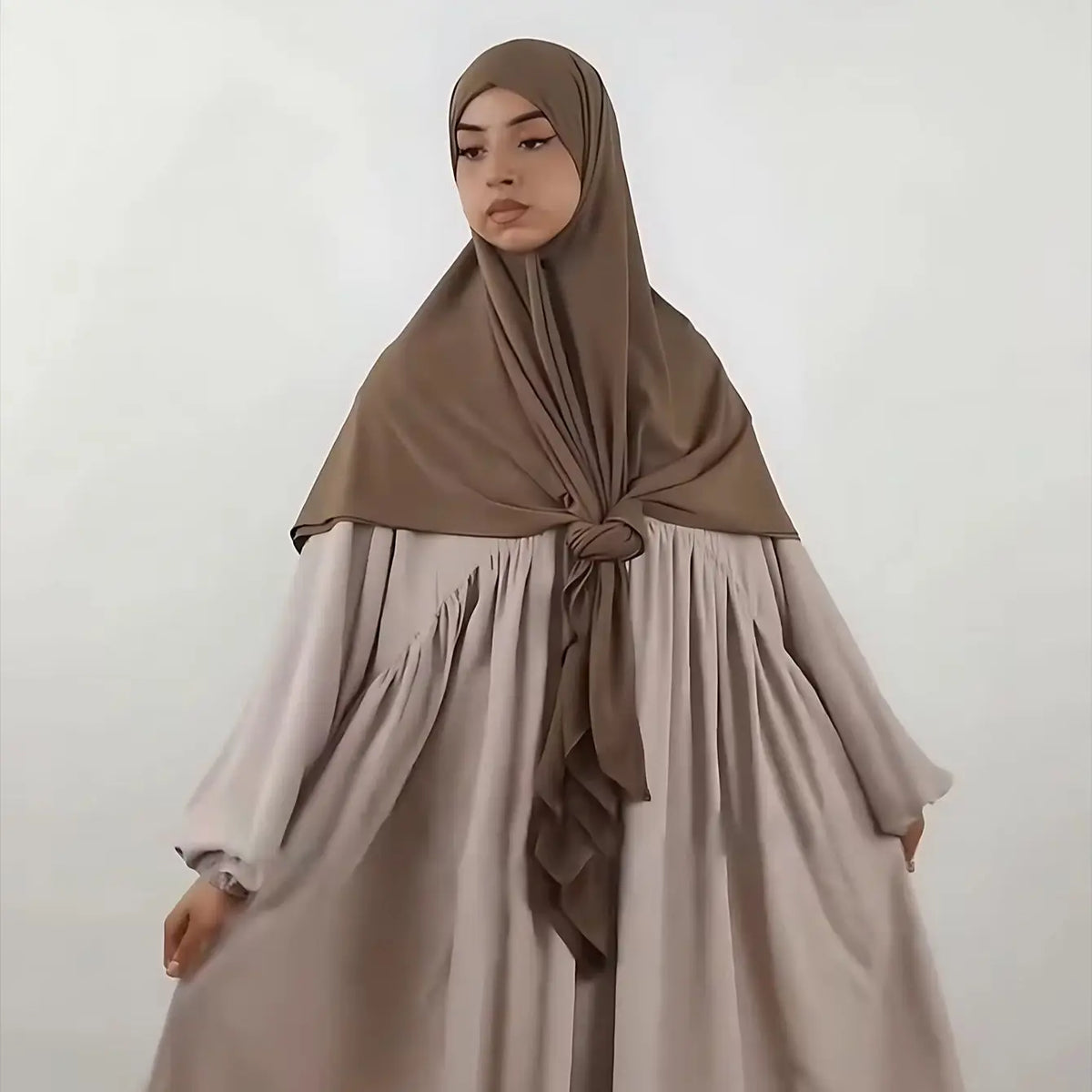 A woman wearing a beige large size stretchy modal square scarf and matching dress for Islamic wear.