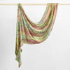 Écharpe hijab en satin de soie imprimée, rose, vert et beige, drapée sur un cintre.