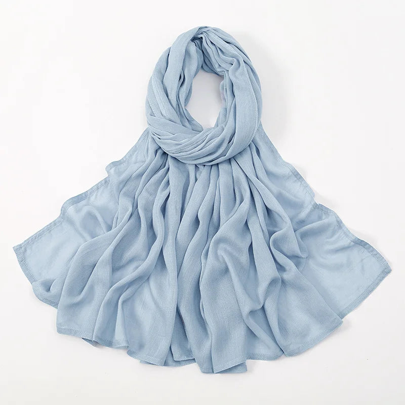 Helles blaues, einfaches Viskose-Hijab elegant um den Hals und die Schultern drapiert.