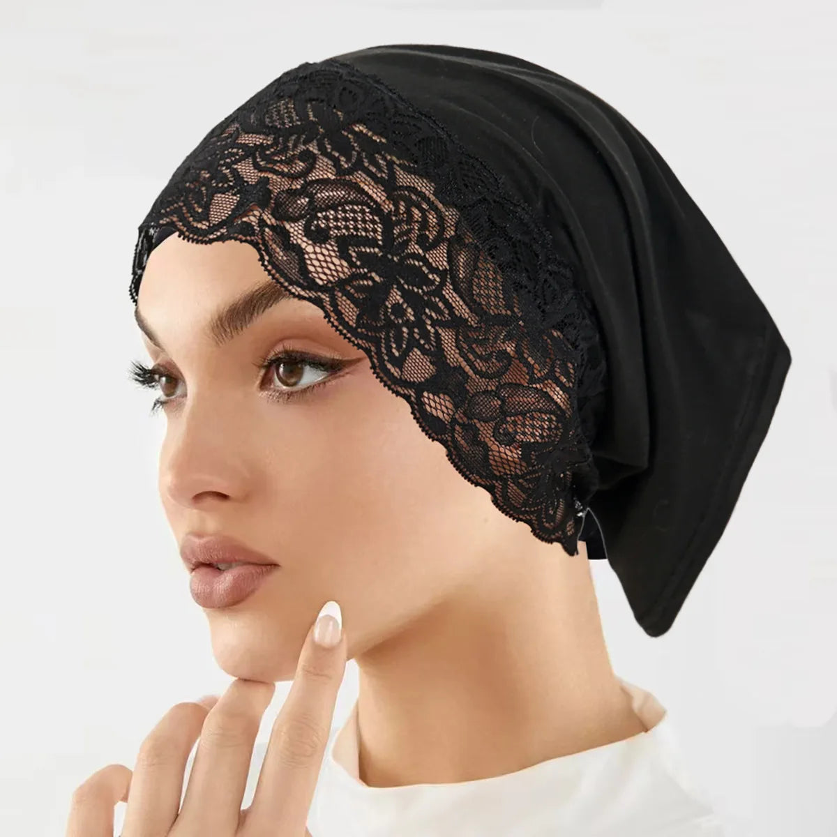 Nahaufnahme einer Frau mit schwarzem Spitzenstrick als Unterhijab-Turbanmütze.