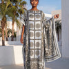 Eine Frau modelliert ein elegantes bedrucktes Seidenkaftan-Kleid in Schwarz, Weiß und Beige im Freien.