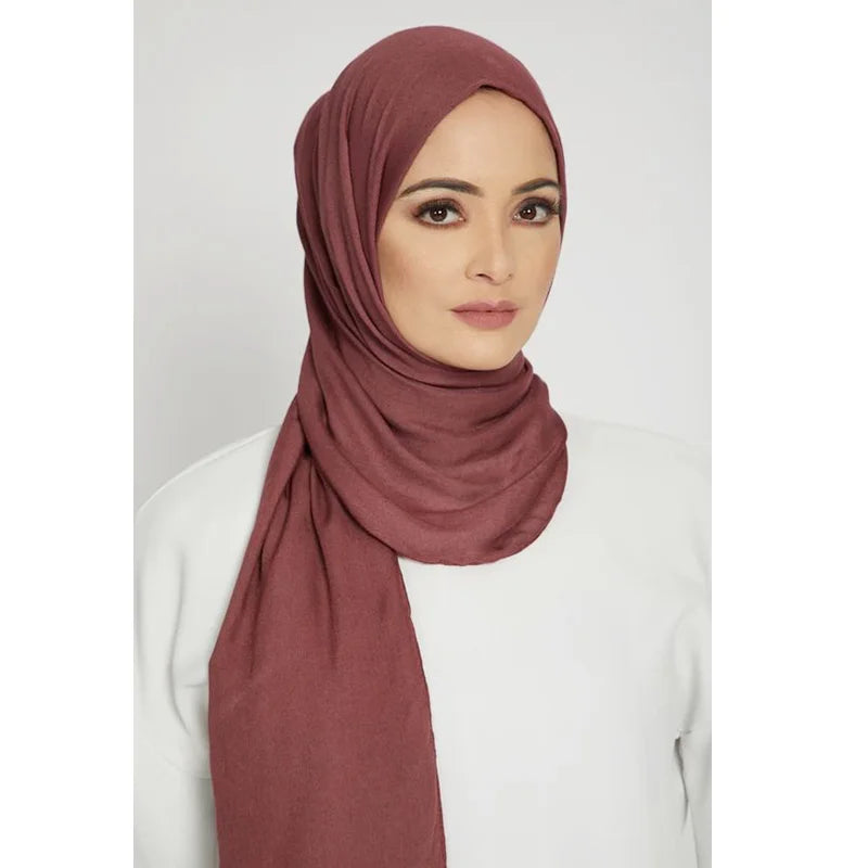 Una mujer usando un pañuelo de hijab de algodón modal premium color rosa empolvado
