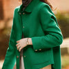 Une femme portant un manteau en laine vert émeraude par-dessus un haut de couleur claire.